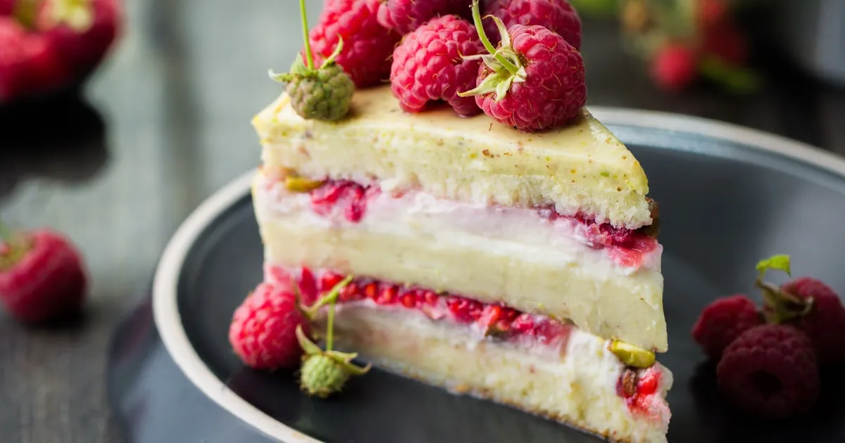 Repostera decorando una tarta de frutas en una cocina doméstica luminosa y ordenada